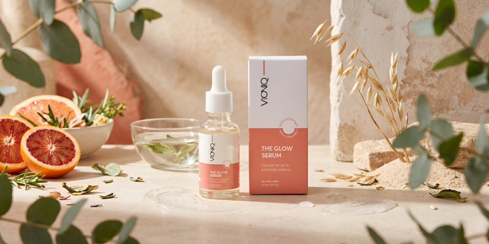 Glow serum bottle and product packaging in a soft studio setting